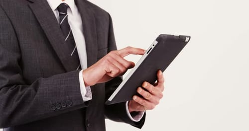 Mid-section of businessman using digital tablet