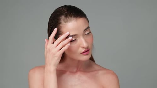 Woman Touches Face and Smiles in Studio