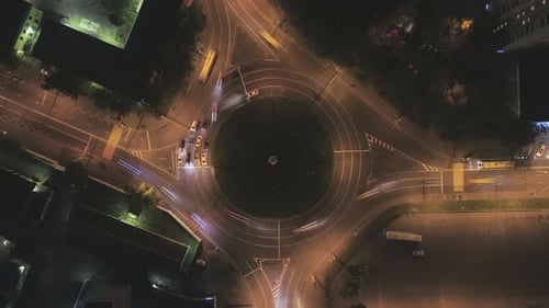 Illuminated Traffic Circle in the City and Cars Traffic at Night. Round Crossroad. Aerial Time Lapse