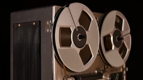 Vintage Reel to Reel tape recorder playing music close up of reel