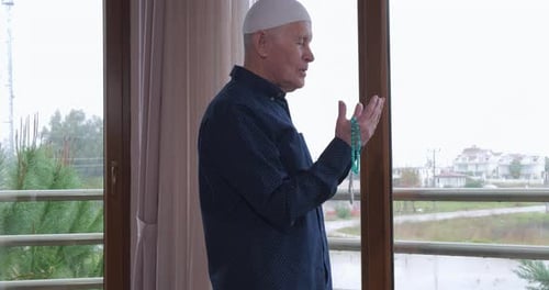 Ein alter Mann mit Rosenkranzperlen betet
