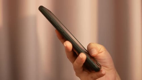 Hand Holding a Black Smartphone