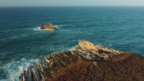 Aerial Footage of Isolated Rocky Formation Within the Sea