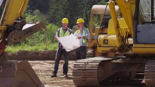 Construction Workers Reviewing Blueprints on Site