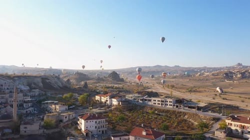 Hot Air Balloons Flying Over Goreme Village at Cappadocia, Turkey.