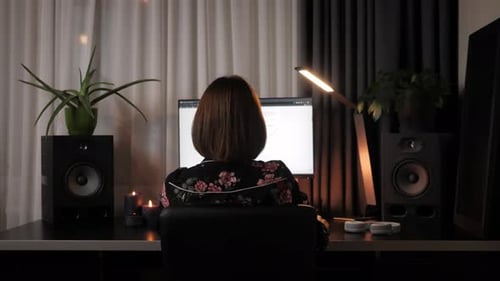 Mujer joven trabajando en el escritorio de la oficina por la noche.