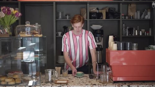 Redhead Man Smiling Behind Cafe Counter