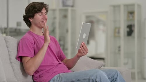 Young Man on Couch Video Calling with Tablet