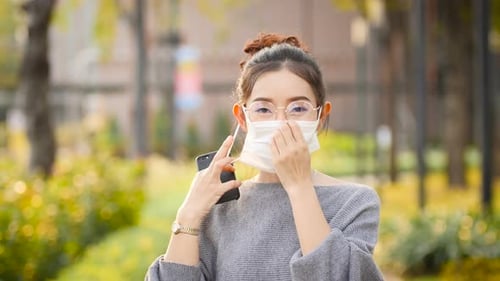 Young Adult Wearing Face Mask While Using Cellphone