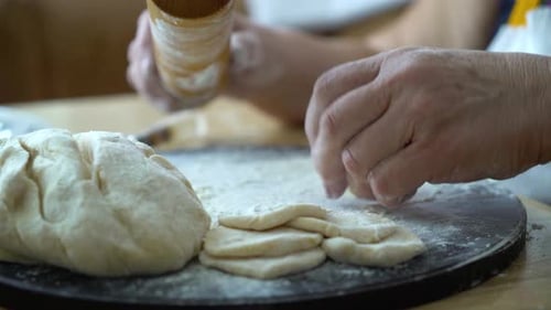 Hands Flattening Dough with a Rolling Pin