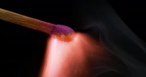 Dramatic Matchstick Flame Burning in Dark