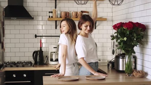 Two Women Dancing Together in Modern Kitchen
