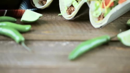 Ground beef tacos with romaine lettuce, diced tomatoes, and shredded cheddar cheese.