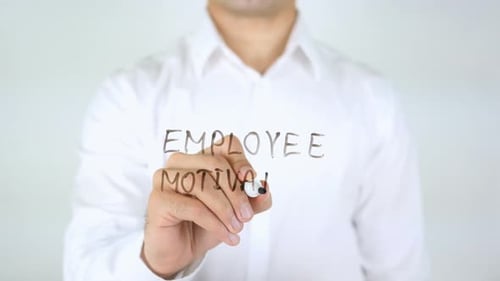 Man Writes Employee Motivation on Clear Surface