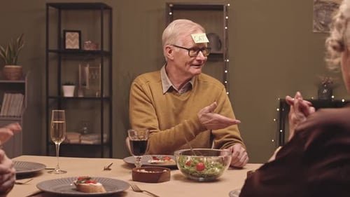 Senior Friends Playing a Game at Dinner Table