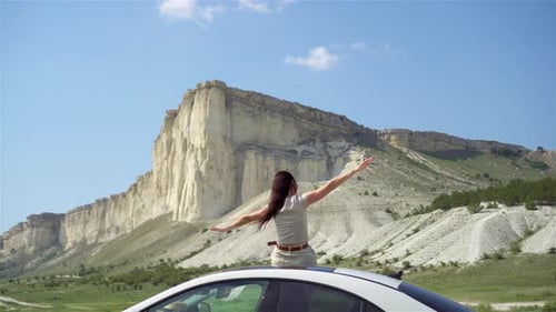 Woman Enjoying Mountain View from Car Roof