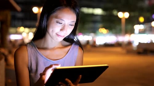 Asian Woman Use of Tablet Computer at Night