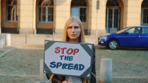 Young Woman Holding Sign in City Street