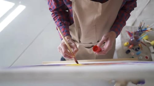 The Artist Paints on Canvas and Smears a Brush. Canvas Stands on the Easel.