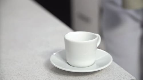 Pouring Coffee into a White Cup from Moka Pot