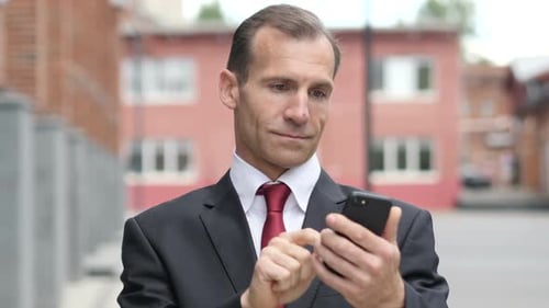 Man in Suit Using Mobile Phone on Street