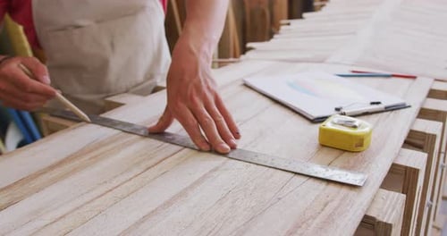 Caucasian male surfboard maker working in his studio and making a wooden surfboard