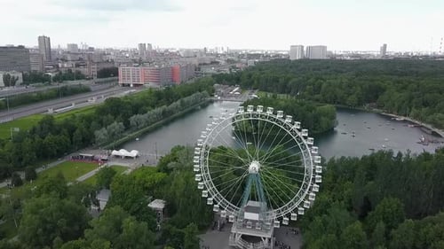 An Aerial Urban View with a Green Park Area with a Ferris Wheel in It