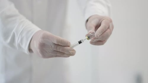 Medical Professional Preparing Syringe in Clean Setting