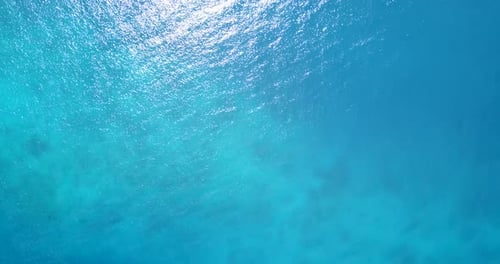 Daytime overhead travel shot of a paradise sunny white sand beach and aqua turquoise water background