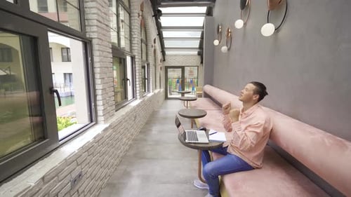 Young Adult Using Laptop in Stylish Urban Space