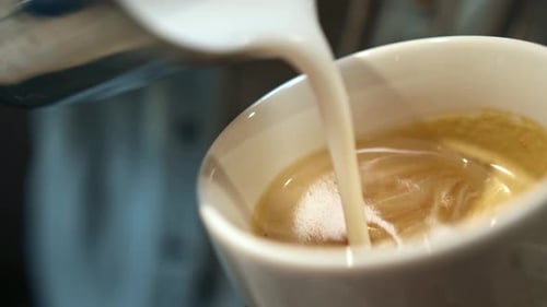Foam Being Poured Into Espresso to Create Latte