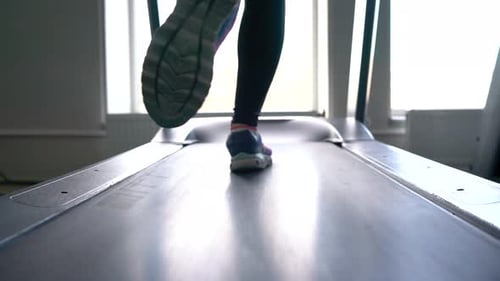 Woman Running on Treadmill in Gym