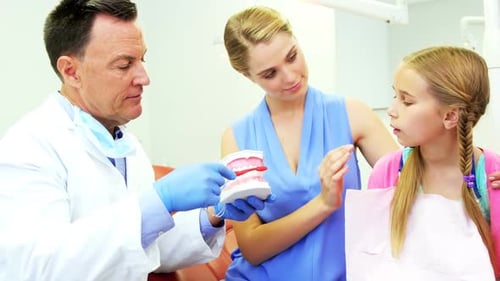 Dentist Explaining Teeth Brushing to Child Patient