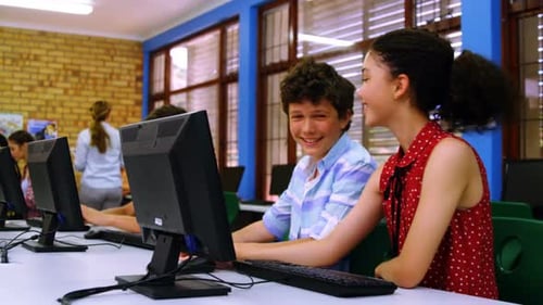 Teens Working Together on Computer in Classroom