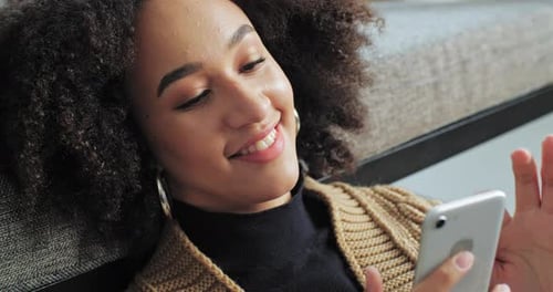 Smiling Woman Using Smartphone Indoors