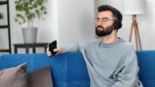 Man Relaxing with Music on Couch Indoors