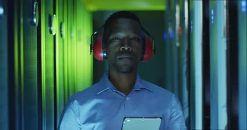 African american male computer technician using tablet working in business server room