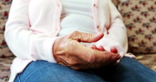 Extreme close up view of retired person rubbing her hands together