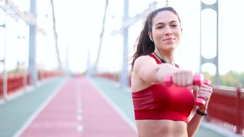 Fit Woman Boxing With Dumbbells on Bridge