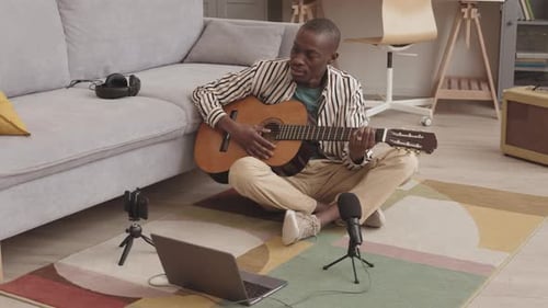 Man Playing Guitar and Singing Indoors