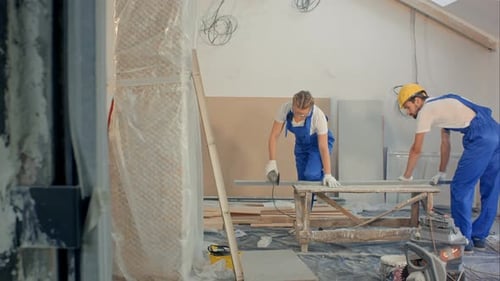 Femme utilisant une scie circulaire dans un immeuble d'appartements