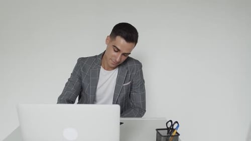 Man Working At Desk With Laptop And Notepad