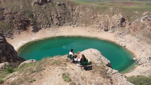 Couple Having A Picnic Watching The Lake On The Hill