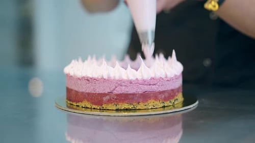 Woman Decorating Cake With Icing in Food Studio