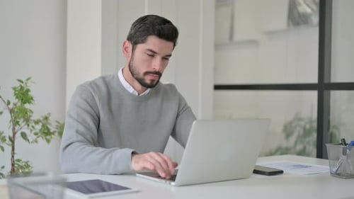 Man Working at Desk Giving Thumbs Up