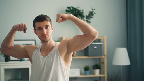 Man Flexing Muscles Indoors