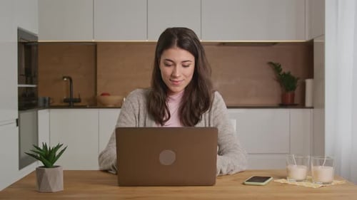 Woman Works on Laptop in Bright Kitchen
