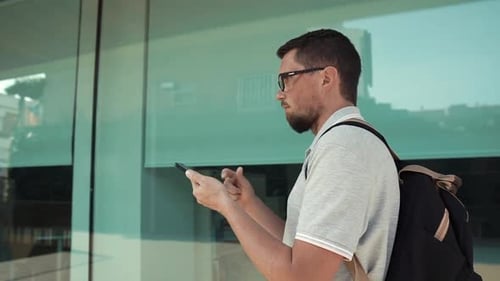 Man Using Mobile Phone Outside Modern Building
