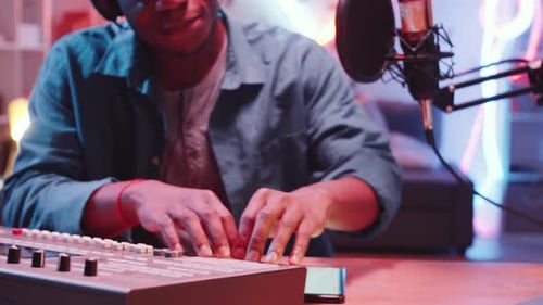 Musician plays electronic keyboard in neon-lit studio