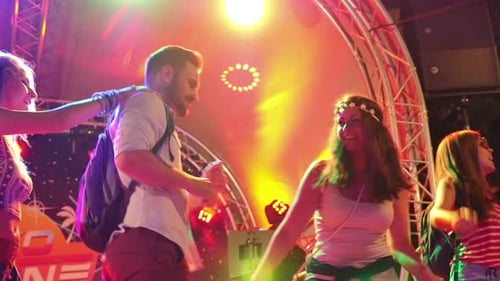 Young Adults Dancing Happily on a Stage at Night